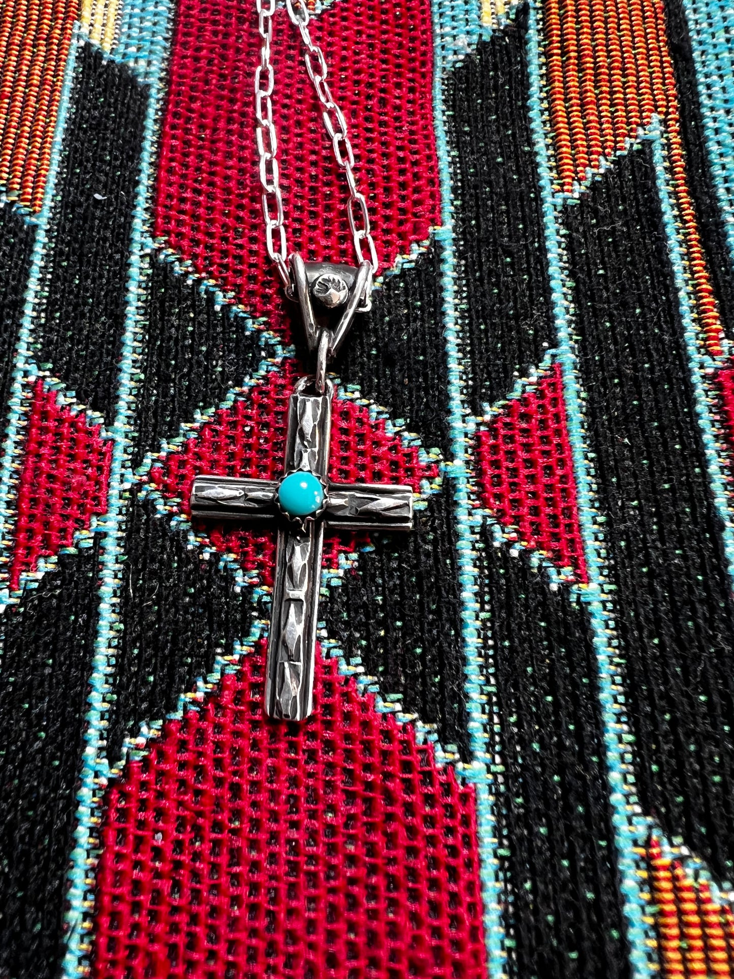 Handmade sterling silver cross with Apache turquoise. 18” Sterling silver chain included.